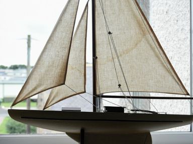 A model sailboat with fabric sails on a windowsill at Portside in Seahouses