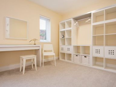 A room with a white desk and stool a white chair and shelving units with cubbies at Summerfold in Warkworth