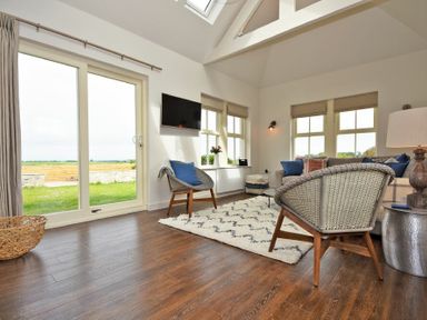 A living room with chairs rug and a television at South View nr Bamburgh in Seahouses