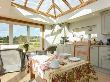 A kitchen and dining area with a skylight and glass doors overlooking a garden at The Lodge Elsdon