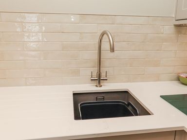 A kitchen sink with faucet and countertop at Cuddy's Holm in Seahouses