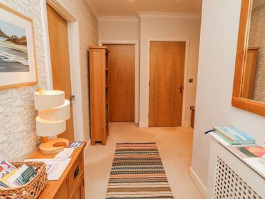 A hallway with doors and a lamp at Cuddy's Holm in Seahouses