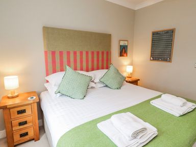 A bedroom with a bed and two bedside tables at Cuddy's Holm in Seahouses