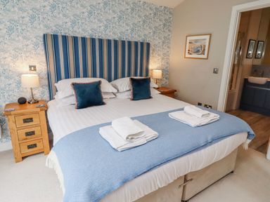 A bedroom with a bed and bedside tables at Cuddy's Holm in Seahouses