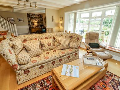 A living room with a sofa and coffee table at Coble Cottage in Craster