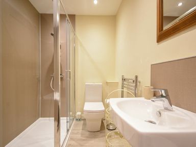 A bathroom with a glass shower enclosure toilet and sink at Sunnybrae Alnmouth