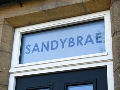A window above a door with the word Sandybrae on the glass at Sandybrae in Alnmouth