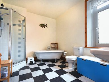 A bathroom with a clawfoot bathtub toilet shower and a sink at Rosedale House in Amble