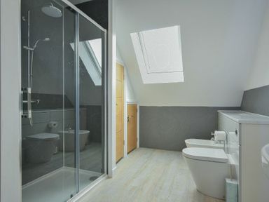 A bathroom with a shower cubicle toilet bidet and skylight at The Chevy in Seahouses