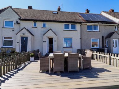An outdoor seating area with table and chairs at Dunford Cottage in Bamburgh