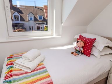 A bedroom with a bed and a stuffed toy at Dunford Cottage in Bamburgh
