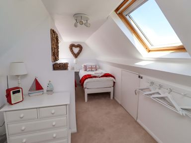 A bedroom with a bed and dresser at Dunford Cottage in Bamburgh