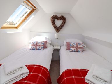 A bedroom with two beds and a heart decoration at Dunford Cottage in Bamburgh