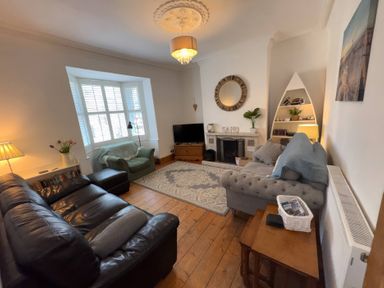 A living room with a sofa and television at Anchor Cottage (Seahouses)