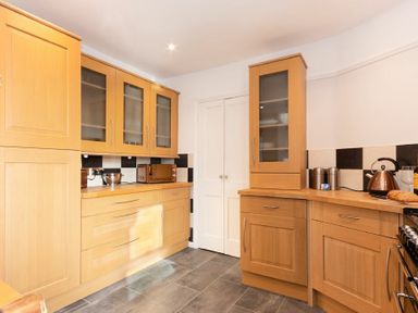A kitchen with wooden cabinets a microwave kettle and toaster on the countertop at Church View in Bamburgh