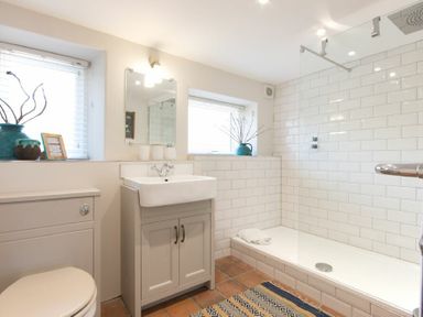 A bathroom with a toilet sink and walk in shower at Cargoes in Craster