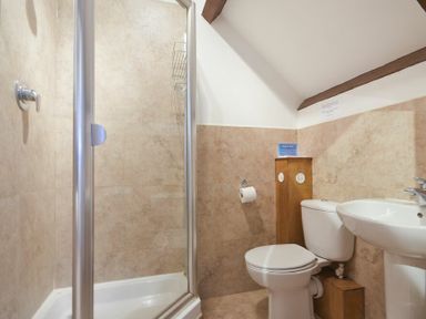 A bathroom with a shower enclosure toilet and sink at The Warren in Bamburgh