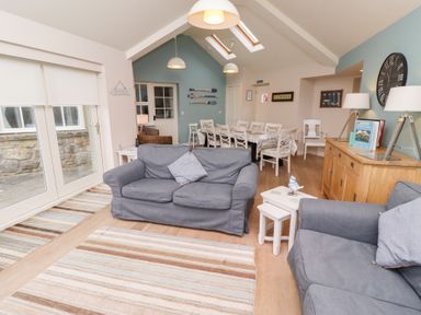 A living room with sofas a dining table with chairs skylights and a sideboard at The Wynd in Bamburgh