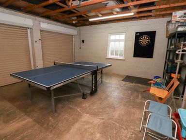 A room with a ping pong table and a dartboard on the wall at The Wynd in Bamburgh