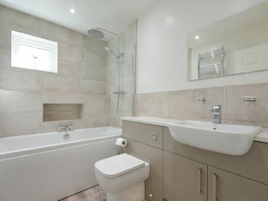 A bathroom with a bathtub shower toilet sink and a wall mirror at Luna Tide in Seahouses