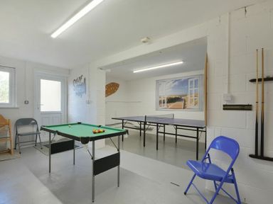 A games room with a pool table ping pong table and chairs at Luna Tide in Seahouses