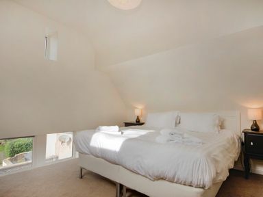 A bedroom with a double bed and bedside tables with lamps at The Old Concert Room in Alnmouth