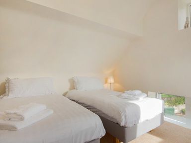 A bedroom with two single beds and towels on them at The Old Concert Room in Alnmouth