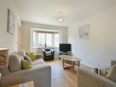 A living room with two sofas armchair coffee table and television at Coast View in Beadnell
