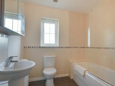 A bathroom with a sink toilet bathtub and a window at Coast View in Beadnell