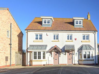 A two-story semi-detached house with tiled roof and brick driveway at Coast View in Beadnell