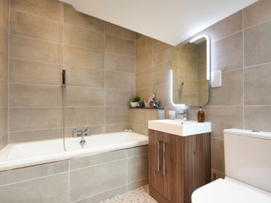 A bathroom with a bathtub sink with cabinet mirror and toilet at Bradacar in Seahouses