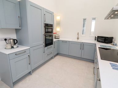 A kitchen with cabinets and appliances at Dell Point in Beadnell