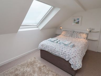 A bedroom with a bed and natural light at Dell Point in Beadnell