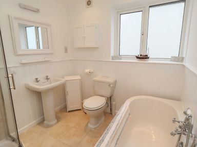 A bathroom with a sink, toilet, and bath tub at Dell Point Beadnell