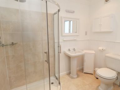 A bathroom with a shower, sink, and toilet at Dell Point in Beadnell