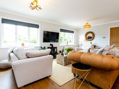 A living room with sofas a television and a coffee table at Polished Pebble in Beadnell