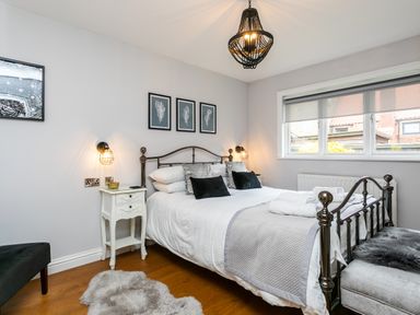 A bedroom with a metal bed frame pillows and bedside tables at Polished Pebble in Beadnell