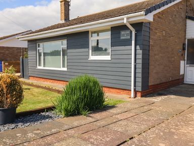 The exterior of a single-story house with a driveway and small garden area at Willow in Beadnell