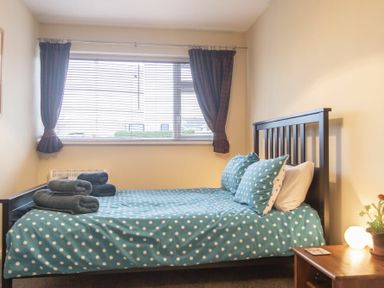 A bedroom with a bed covered in polka dot bedding and towels on the bed at Our Story Cottage in Longhoughton