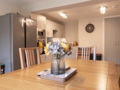 A kitchen with a dining table with flowers in a vase at Southfield Lodge in Seahouses