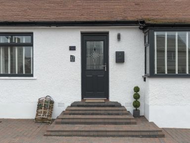 A front door with steps leading up to it and windows on either side at Southfield Lodge in Seahouses