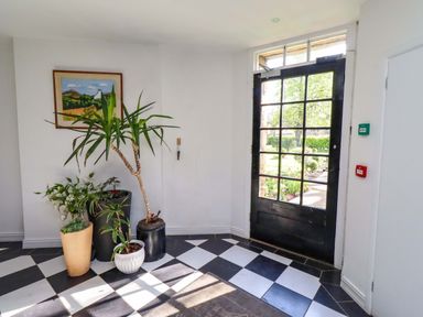 A hallway with plants and a door at Treetops, Alnwick