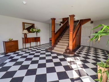 A hallway with stairs and a table at Treetops, Alnwick