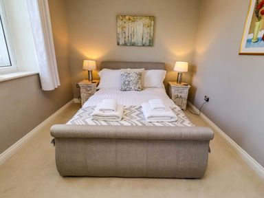 A bedroom with a bed and nightstands at Treetops, Alnwick