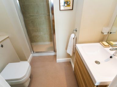 A bathroom with a toilet shower area and sink at The Beach House Alnmouth