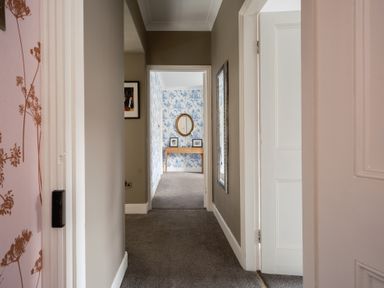 A hallway with a mirror and table at Westhill House Warkworth