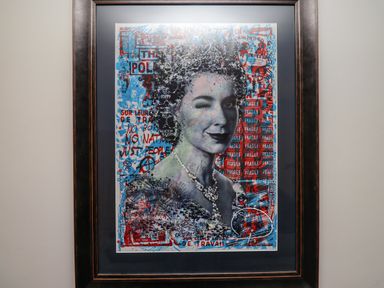 A framed artwork of a winking woman with collage elements and text on a wall at Muscle Shoals in Seahouses