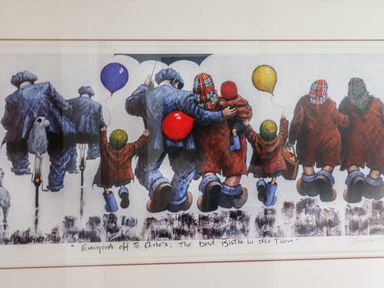A framed artwork showing people walking away with balloons and a dog on a bicycle at Muscle Shoals in Seahouses