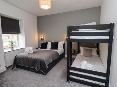 A bedroom with a double bed and black bunk beds at Muscle Shoals in Seahouses