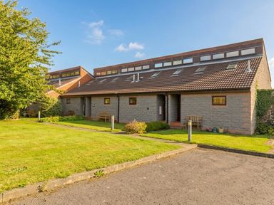 A house with benches and grass at Links View in Embleton